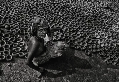 A potter looks up from his work towards the camera | Photo: Zahidur Rahman