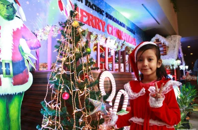 A young girl poses infront of a Christmas tree in Sonargaon hotel | Focus Bangla