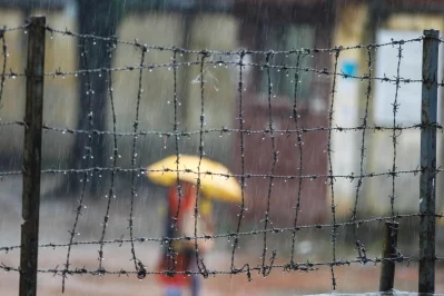 A woman walks by in the rain with an umbrella | Mahmud Hossain Opu