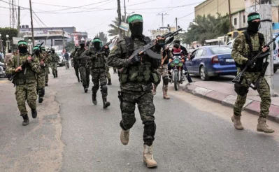 Fighters from the Ezzedine al-Qassam Brigades, the armed wing of the Palestinian Hamas movement, take part in a military show ahead of the 30th anniversary of the movements founding in the southern Gaza Strip city of Khan Yunis on December 5, 2017 (AFP)