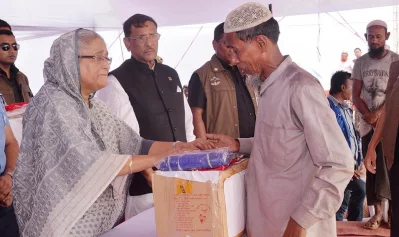 The prime minister gets emotional while distributing relief goods to an elderly Rohingya man. Awami League General Secretary Obaidul Quader is seen standing right beside her | Focus Bangla