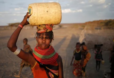 A woman carries a water canister in a village near Loiyangalani, KenyarnrnREUTERS