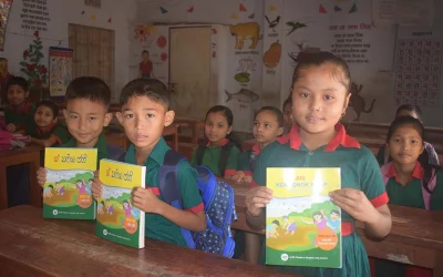 Chakma and Tripura children flaunt their brand-new textbooks in their mother language | Photo by Dhaka Tribune