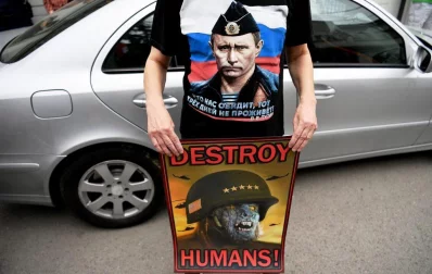 A Serbian protestor wearing a t-shirt showing Russian President Vladimir Putin holds an anti Nato poster, during a demonstration of a few dozen protestors against Western air strikes against Syrias regime, in Belgrade on April 15, 2018.rnThe United States, Britain and France took military action in response to an alleged chemical attack in a Syrian rebel-held town a week ago that killed at least 40 people | AFP