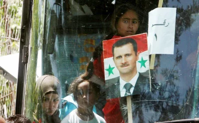 A picture of Syrian President Bashar al Assad is seen on a bus as Syrian refugees who fled to Lebanon go back to Syria from the southern village of Shebaa, Lebanon April 18, 2018 | Reuters