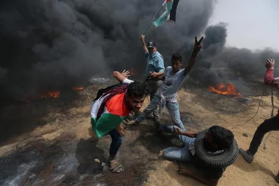 Demonstrators take cover during clashes with Israeli troops at a protest where Palestinians demanded the right to return to their homeland, at the Israel-Gaza border in the southern Gaza Strip, April 20, 2018 | Reuters
