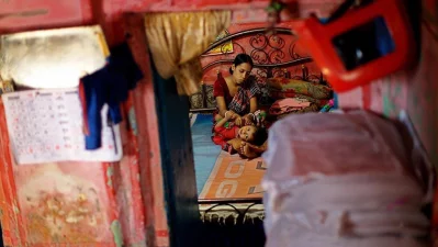 In a hazardous building in Shakhari Bazaar, a mother soothes her child to sleep | Syed Zakir Hossain/Dhaka Tribune