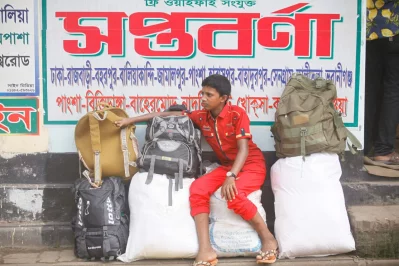 Boy sits atop luggage at the Gabtoli Bus Terminal, waiting to catch a bus out of the city on the day before  Eid-ul-Fitr Mahmud Hossain Opu
