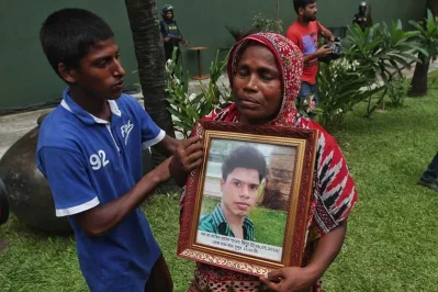 The mother of Zakir Hossain Shaon u2013 a bakery staff u2013 mourns with his portrait on the former site of the bakery | Rajib Dhar/Dhaka Tribune