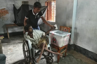A youth helping a man cast his vote in the city polls in RajshahinRajib Dhar/Dhaka Tribune