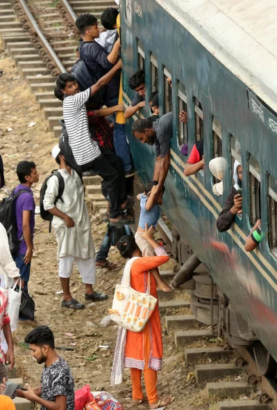 People try desperately to climb onto the roof of a train as the compartments themselves are completely packed, at Dhakas Airport Railway Station ahead of Eid-ul-Azha, August 20, 2018 Syed Zakir Hossain