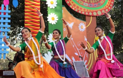Three performers dance on a spring-themed stage during Pohela Falgun festivities  at Charukola, Dhaka University, on February 13, 2019 | Syed Zakir Hossain