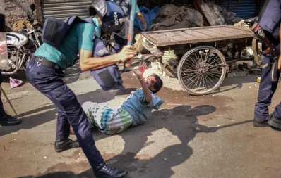 Police official assulting a Bihari resident in Mohammadpur Geneva camp in Dhaka on Saturday, October 5, 2019 Mahmud Hossain Opu/Dhaka Tribune