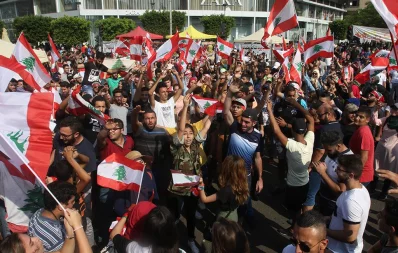 Lebanese protesters wave national flags as they take part in a third day of protests against tax increases and official corruption in the southern city of Sidon (Saida) on October 19, 2019 /AFP
