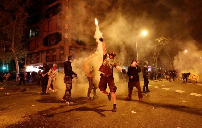 A Catalan demonstrator throws a tear gas canister back to the riot police during Catalonias general strike in Barcelona, Spain on October 18, 2019 /Reuters
