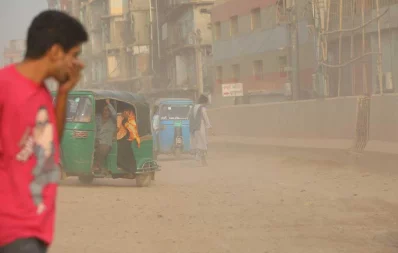 A passerby tries to cover his face to prevent the dust from going into his respiratory system in Postogola in Dhaka on Monday, November 25, 2019  Mehedi Hasan/Dhaka Tirbune