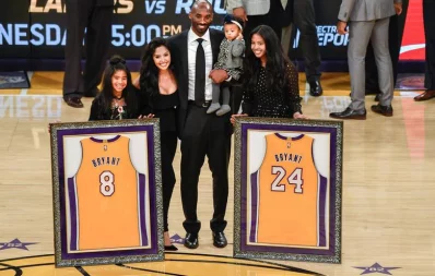 Kobe Bryant and family pose for a photo during a halftime ceremony to retire his two numbers at Staples Center in Los Angeles on December 18, 2017 Reuters