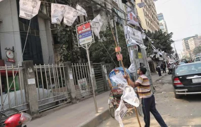 A city corporation worker takes down election posters, used in Dhaka city polls, on February 2, 2020 | Rajib Dhar/Dhaka Tribune