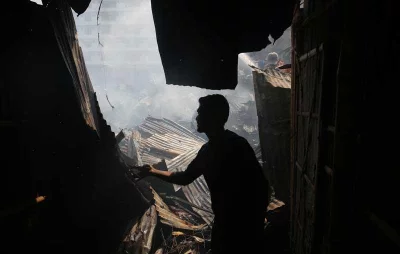 A man try to douse the fire that broke out at Shialbari Jhilpar Slum in Rupnagar area at Mirpur 6 on Wednesday, March 11, 2020 Mahmud Hossain Opu/Dhaka Tribune