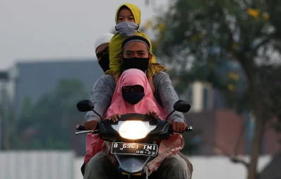 Indonesian Muslims ride a motorbike to attend mass prayers to celebrate Eid al-Fitr, the Muslim festival marking the end the holy fasting month of Ramadan, amid the spread of coronavirus disease (COVID-19) outbreak in Bekasi, on the outskirts of Jakarta, Indonesia, May 24, 2020 Reuters