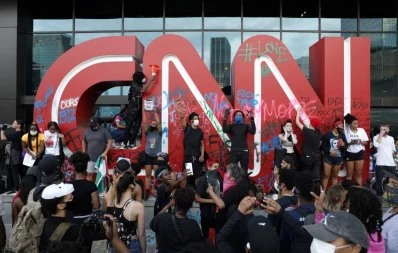 Protesters stand in front of a vandalized CNN logo in front of the CNN Center during a protest against the death in Minneapolis police custody of African-American man George Floyd, in Atlanta, Georgia, US May 29, 2020nReuters