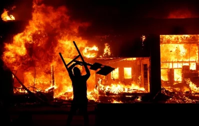 A protester holds an object in front of a fire during a demonstration against the death in Minneapolis police custody of African-American man George Floyd, in Minneapolis, Minnesota, US, early May 30, 2020nReuters