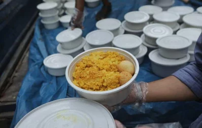 A volunteer hands over foods for iftar to a woman, under Dhaka Tribunes Share Your Meal initiative for the underprivileged people of Dhaka city, in Hazaribagh area on Sunday, May 17, 2020 Rajib Dhar/Dhaka Tribune