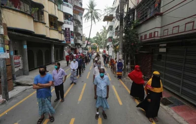 A volunteer hands over foods for iftar to a woman, under Dhaka Tribunes Share Your Meal initiative for the underprivileged people of Dhaka city, in Hazaribagh area on Sunday, May 17, 2020 Rajib Dhar/Dhaka Tribune