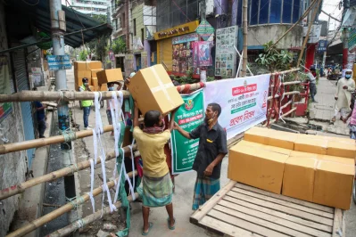 Workers carry cartons over the barricade in Wari on Monday, July 7, 2020 | Mehedi Hasan/Dhaka Tribune