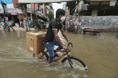 A man carries a carton on his bicycle as he wades  through rainwater at Green Road area in Dhaka on Monday, July 20, 2020 | Rajib Dhar/Dhaka Tribune