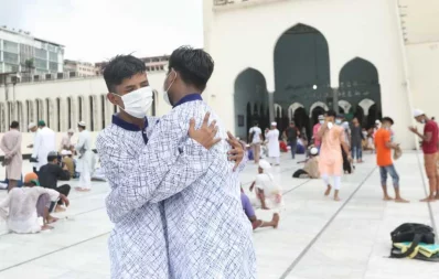 Two men embrace after the Eid prayers outside mosque on Saturday, August 1, 2020 Rajib Dhar/Dhaka Tribune