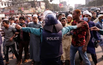 A police member attempts to block oncoming protesters near Baitul Mukarram National Mosque in Dhaka on Friday, December 4, 2020 Mahmud Hossain Opu/Dhaka Tribune