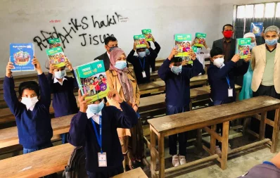 Fourth-graders of Jessore Zilla School show off their stacks of new textbooks in their classroom on Friday, January 1, 2021 Dhaka Tribune