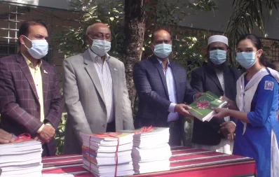 State Minister for Social Welfare Ashraf Ali Khan Khosru hands over new text books to a student of Netrakona Government Girlsu2019 High School on Friday, January 1, 2021 Dhaka Tribune