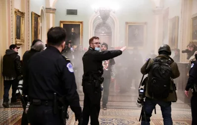 Supporters of President Donald Trump set off a fire extinguisher after breaching security defenses, as police move in on the demonstrate on the second floor of the US Capitol near the entrance to the Senate, in Washington, US, January 6, 2021 Reuters