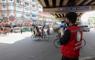 A volunteer uses a loudspeaker to raise awareness on the first day of the week-long lockdown in Dhaka on Monday Mehedi Hasan/Dhaka Tribune
