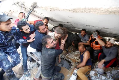 Rescuers carry Suzy Eshkuntana, 6, as they pull her from the rubble of a building at the site of Israeli air strikes, in Gaza City May 16, 2021 Reuters