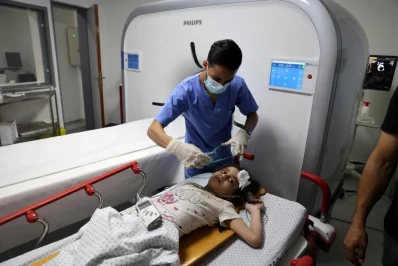 Palestinian girl Suzy Eshkuntana, 6, is treated by a medic at a hospital after being pulled from the rubble of a building amidst Israeli air strikes, in Gaza City May 16, 2021 Reuters