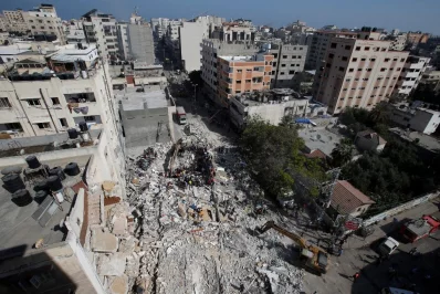 Rescuers search for people in the rubble of a building at the site of Israeli air strikes, in Gaza City May 16, 2021 Reuters