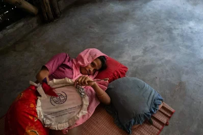 nRohingya refugee Romiza Begum breastfeeds her child at a camp in Coxs Bazar, Bangladesh, on Wednesday, August 11, 2021. Romiza is now sharing a temporary shelter with two other families after heavy rains, landslides, and floods destroyed her previous shelter two weeks ago. Allison Joyce/Dhaka Tribunen