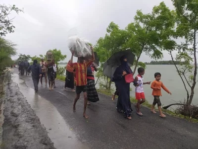Cyclone Amphan - As the flood water entered the village of Ashashoni, Protabnagar, Sathkhira the day after the cyclone Amphan, People take all the essential things and move to another place to take shelter as their houses are about to get submerged in flood water.