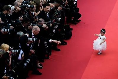 A young guest pose in front of photographers on the red carpet before the screening of "Final Cut (Coupez !)" ahead of the opening ceremony of the 75th edition of the Cannes Film Festival in Cannes, southern France, on May 17, 2022 AFP