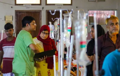 The image shows a doctor checking up on patients at the dedicated dengue ward in Mugda Medical College Hospital on Saturday, September 16, 2023. Photo: Mehedi Hasan/Dhaka Tribune