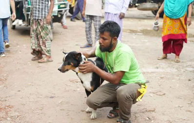 An employee who immunizes for rabies petting a dog. Photo: Courtesy