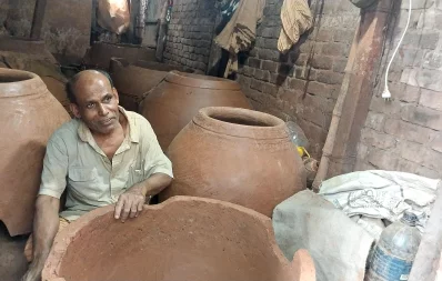 The undated photo shows the potter Paran Babu holding a tandoor stove at his shop in Rayerbazar area of Dhaka . Photo: Famiha Suhrawardy/Dhaka Tribune