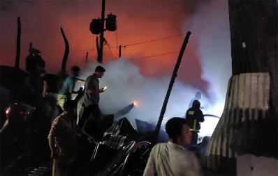 Firefighters and locals work to douse a blaze at Baburhat-Shekherchar market in Narsingdi on Monday, October 30, 2023. Photo: UNB