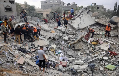 Civilians and rescuers look for survivors amid the rubble of a destroyed building following an Israeli bombardment in Khan Yunis on November 12, 2023. Photo: AFP