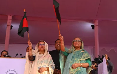 Prime Minister Sheikh Hasina and her sister Sheikh Rehana wave Bangladesh’s flag after reaching the stage of Sylhet Govt Alia Madrasa on Wednesday, December 20, 2023. Photo: Ali Asif Shawon