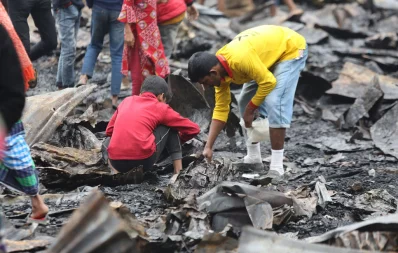 People look through the remains after a fire burnt down Mollabari slum adjacent to the Bangladesh Film Development Corporation (BFDC) gate in Tejgaon area of the capital on Saturday, January 13, 2024. Photo: Mehedi Hasan/Dhaka Tribune