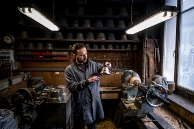 Alois Huguenin checks the sound of a bell in his foundry